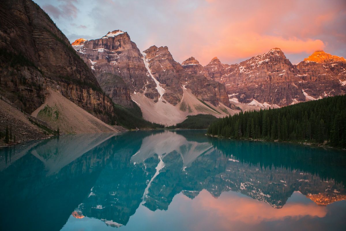 Turquoise lake beneath sunlit mountain peaks